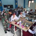 Dukung Program Pemerintah, Babinsa Tulungwulung Dampingi Distribusi Makanan Bergizi