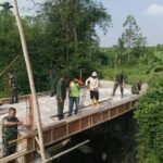 Anggota Koramil Sukun Gotong Royong Rakit Rangka Pagar Jembatan Perintis Garuda